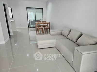 Spacious modern living room with sleek tile flooring and cozy sectional sofa.