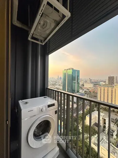 High-rise balcony with washing machine and stunning city view at sunset.