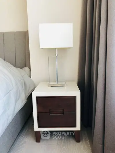 Stylish bedroom nightstand with modern lamp and elegant curtains