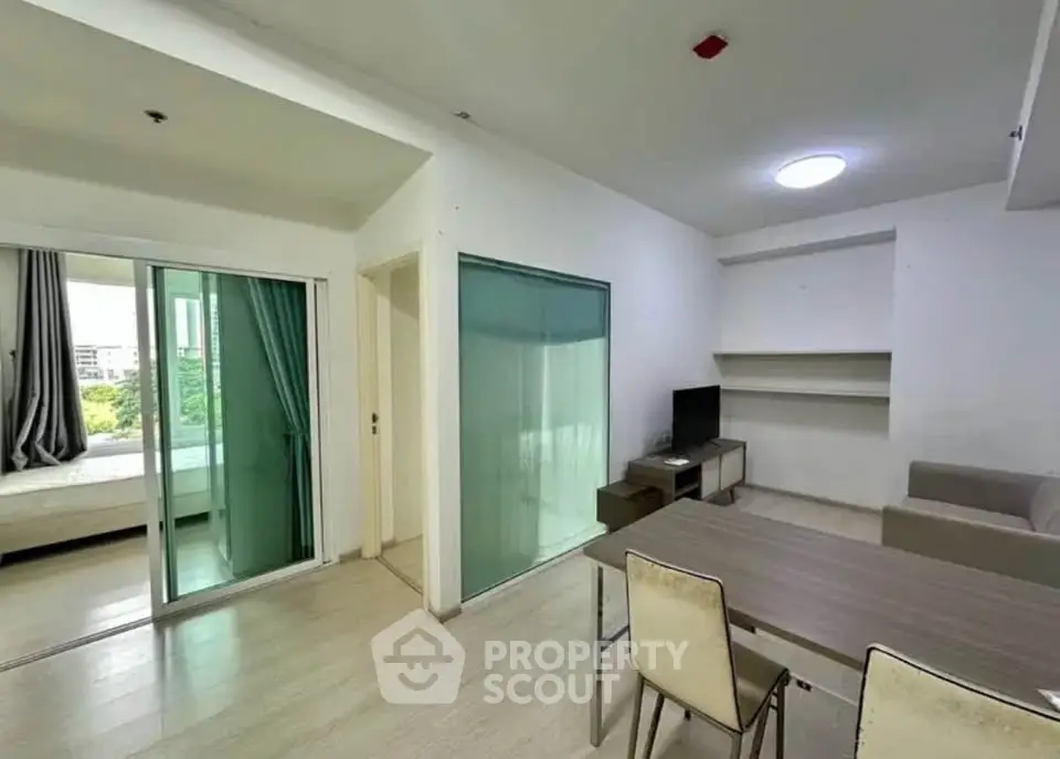 Modern apartment interior with open living and dining area, featuring sleek furniture and natural light.