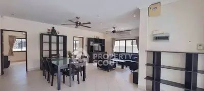 Spacious living room with modern furniture and dining area, featuring ceiling fans and ample natural light.