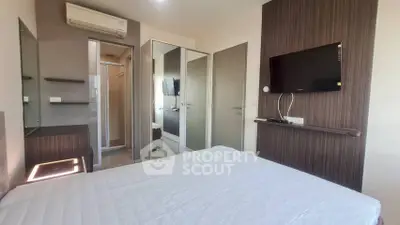 Modern bedroom with wall-mounted TV and air conditioning in a stylish apartment.