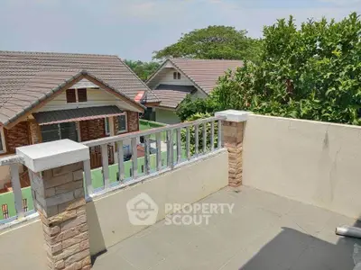 Charming balcony with scenic view of suburban rooftops and lush greenery.