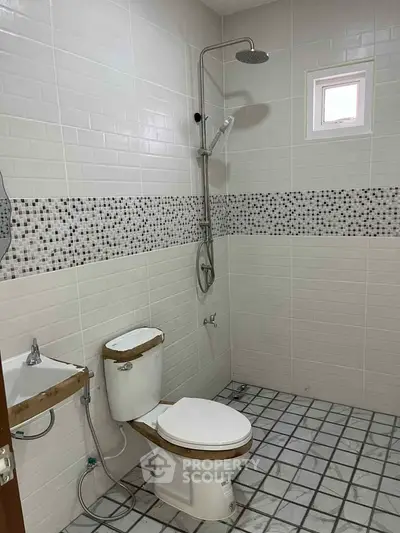 Modern bathroom with shower and toilet featuring stylish tile design.