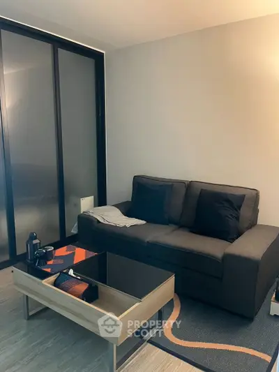 Modern living room with sleek sofa and stylish coffee table in cozy apartment.