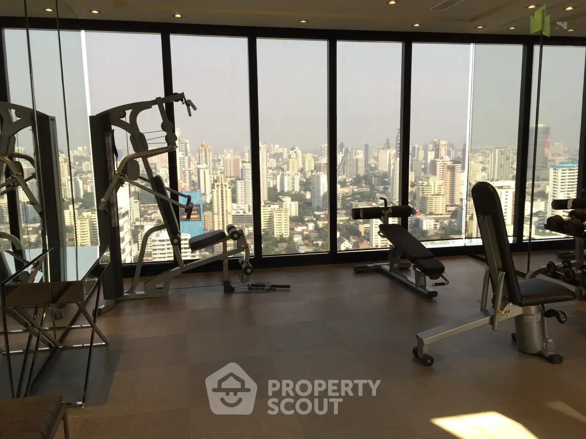 Luxury gym with panoramic city view and modern fitness equipment.