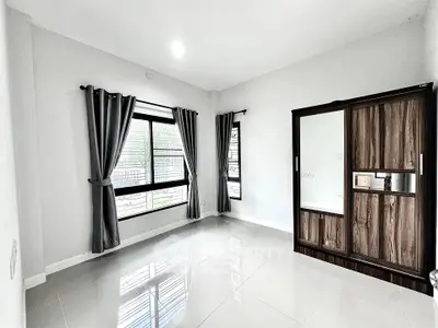 Spacious bedroom with large windows and modern wardrobe, perfect for natural light lovers.