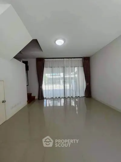 Spacious empty living room with large window and elegant curtains