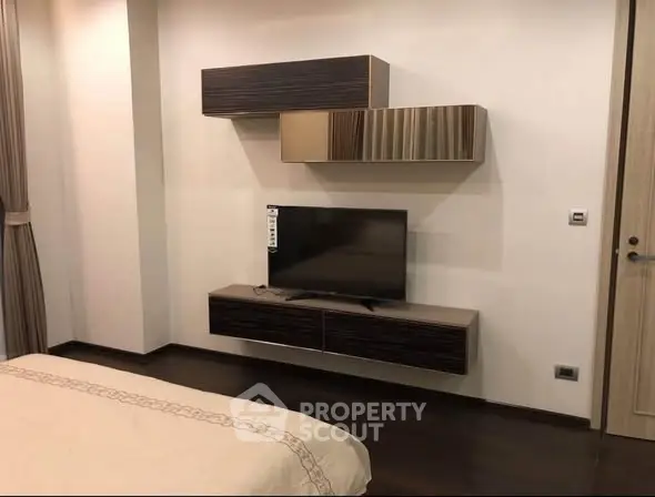 Modern bedroom with sleek TV unit and stylish wall cabinets