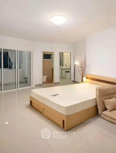 Spacious bedroom with modern design and large windows for natural light.