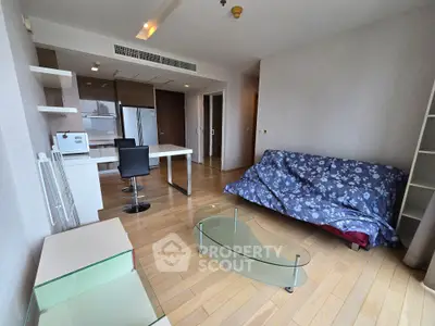 Spacious modern living room with open kitchen and stylish glass coffee table.