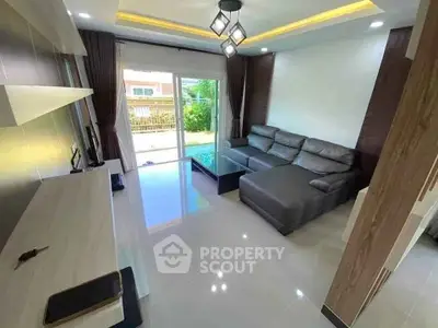 Modern living room with sleek design, large sectional sofa, and natural light from sliding glass doors.