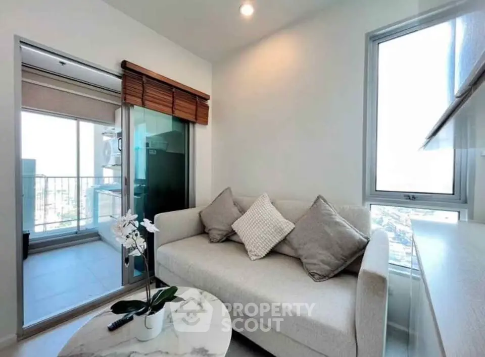 Modern living room with cozy sofa and balcony view in a bright apartment.