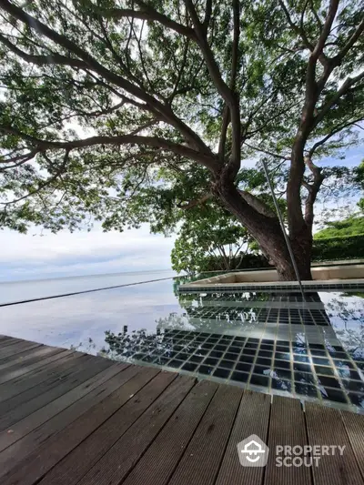 Stunning infinity pool with ocean view and lush greenery, perfect for luxury living.