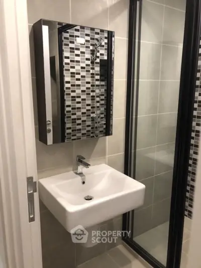 Modern bathroom with sleek sink and stylish tiled shower area