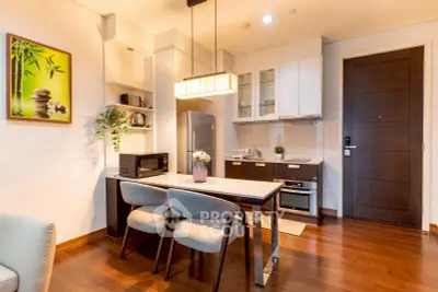 Modern kitchen with dining area, featuring sleek appliances and stylish decor.