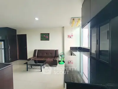 Modern living room with sleek furniture and large windows offering natural light.