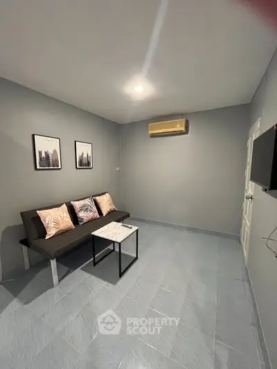 Modern living room with sleek gray walls, stylish sofa, and wall art.