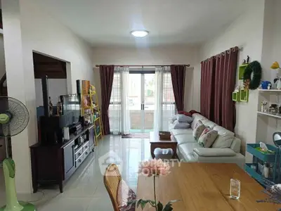 Spacious living room with modern decor and natural light, featuring a cozy seating area and entertainment center.