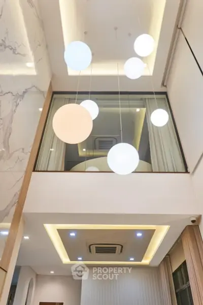 Modern interior with high ceiling and stylish lighting in a luxurious living space.