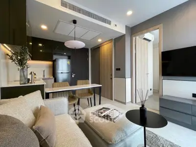 Modern living room with open kitchen, sleek furniture, and stylish decor in a contemporary apartment.