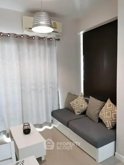 Cozy living room with modern decor and natural light, featuring a comfortable sofa and stylish lighting.