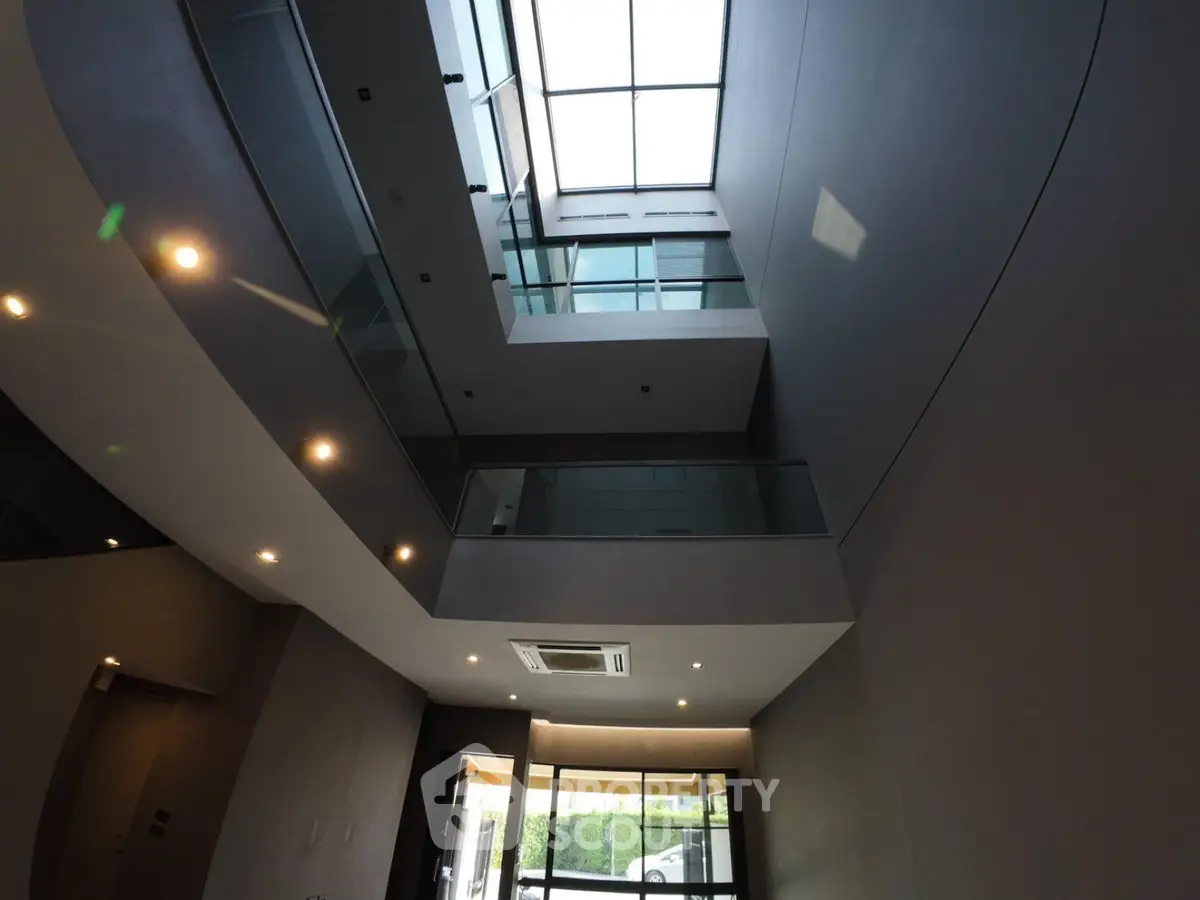 Modern building interior with skylight and glass railings, showcasing contemporary architectural design.