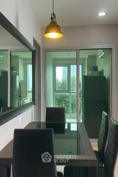 Modern dining area with glass table and leather chairs, overlooking a lush green view.