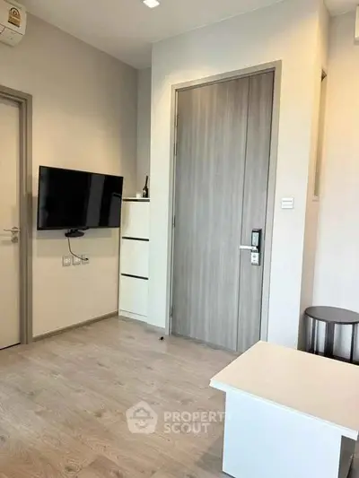 Modern living room with wall-mounted TV and sleek wooden flooring