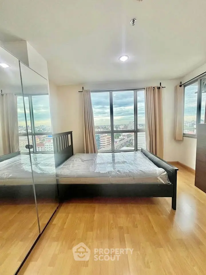 Spacious bedroom with city view and mirrored wardrobe
