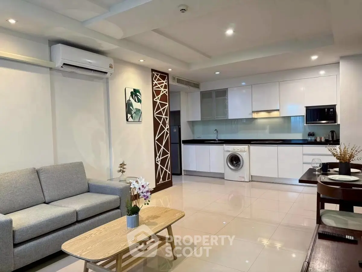 Modern open-plan living room and kitchen with sleek design and appliances.