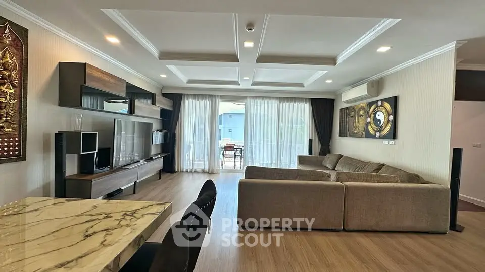 Spacious modern living room with elegant decor and large windows opening to balcony.