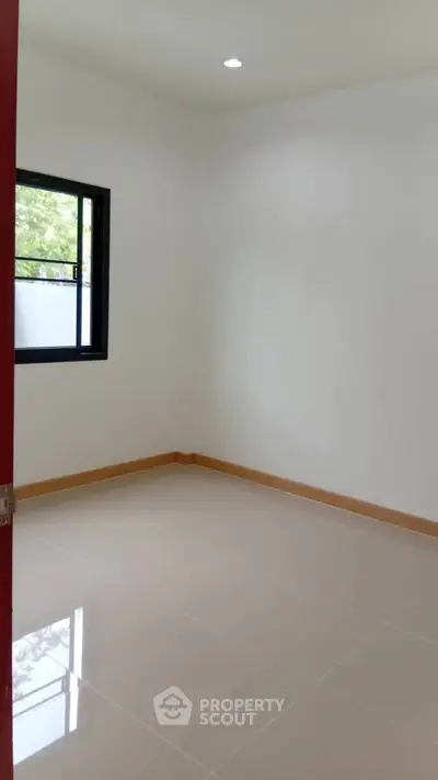 Spacious empty room with glossy tiled floor and natural light