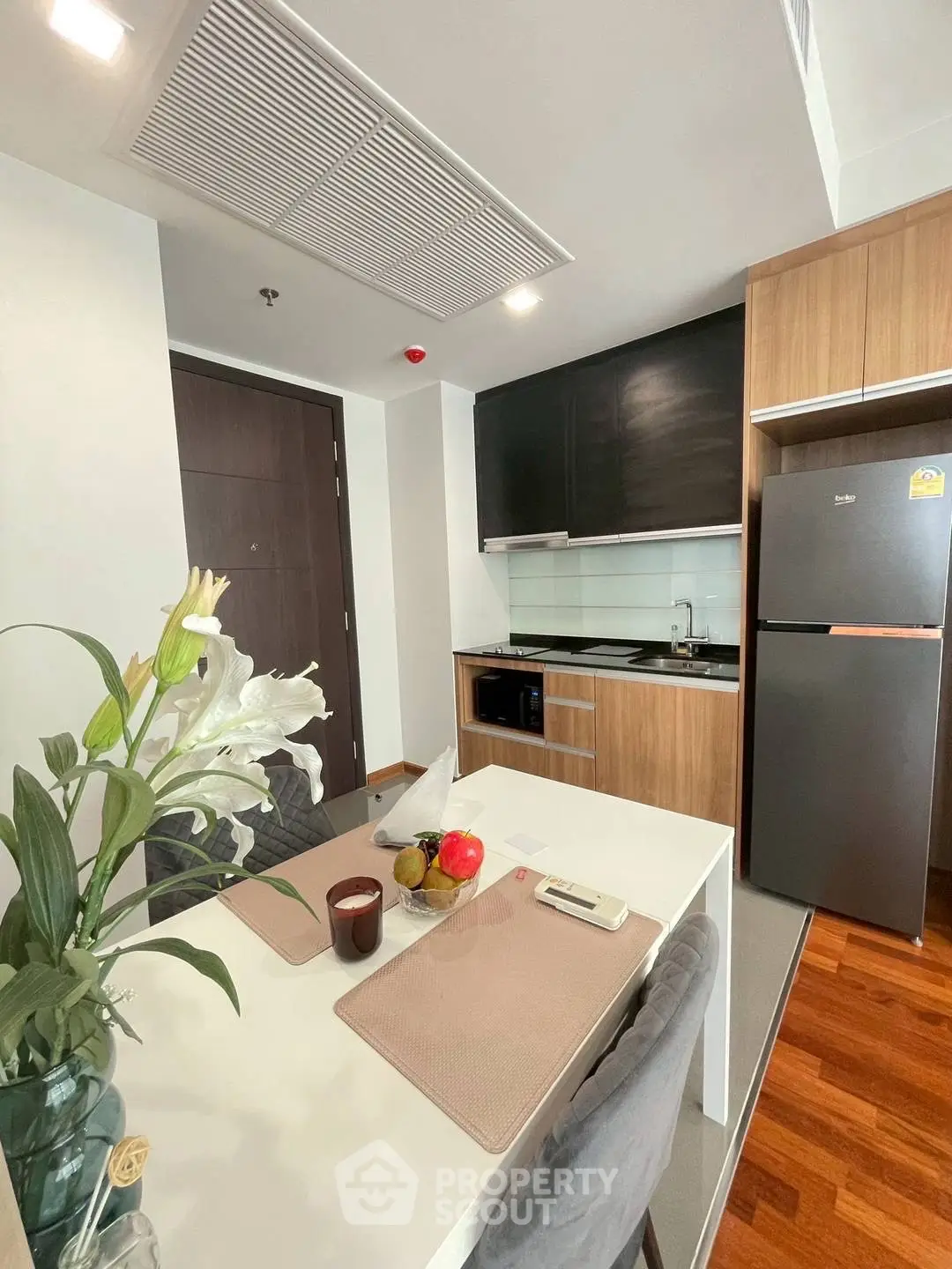 Modern kitchen with sleek appliances and dining area in stylish apartment.