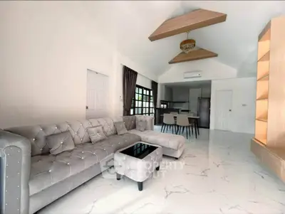 Luxurious open-plan living room with elegant furniture and modern kitchen.