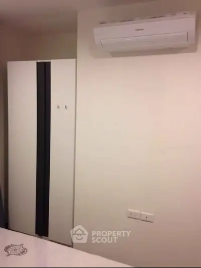 Modern bedroom with sleek wardrobe and air conditioning unit