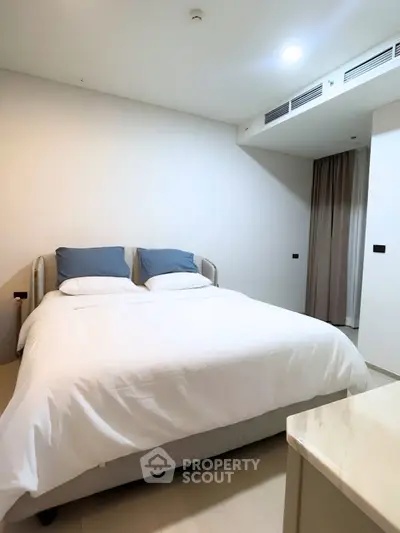 Modern bedroom with cozy bed and minimalist decor in a stylish apartment.