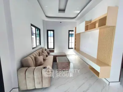 Modern living room with plush sofa and stylish shelving in a bright, airy space.