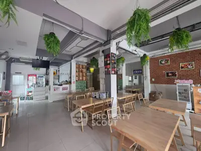 Spacious modern cafe interior with wooden tables and hanging plants