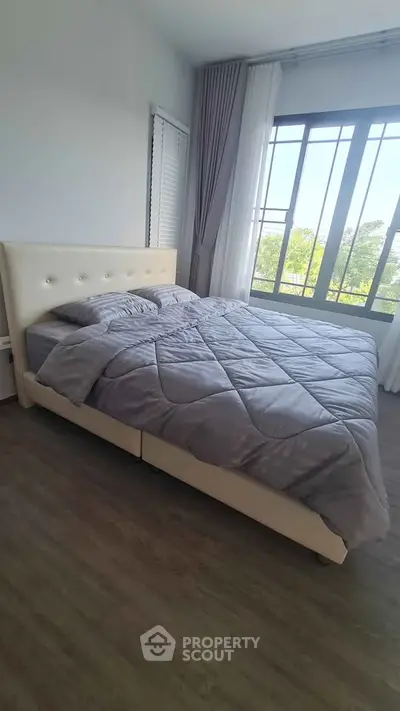 Spacious bedroom with large window and elegant decor
