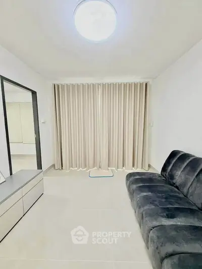 Modern living room with sleek furniture and elegant curtains in a minimalist design.