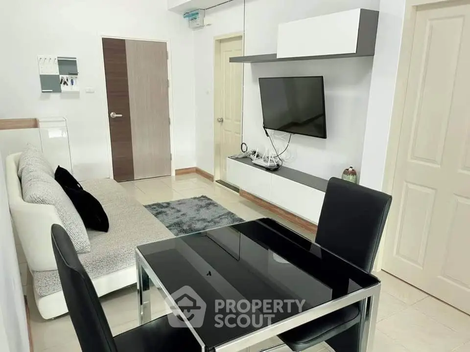 Modern living room with sleek furniture and wall-mounted TV in a stylish apartment.