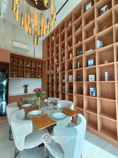 Luxurious dining room with elegant chandelier and extensive bookshelf wall