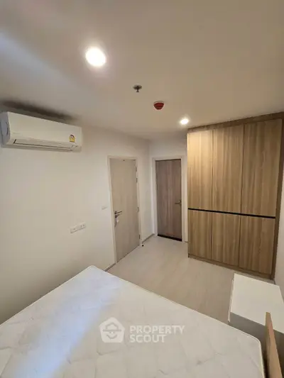 Modern bedroom with built-in wardrobe and air conditioning in a stylish apartment.