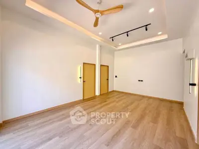 Spacious modern living room with wooden flooring and ceiling fan