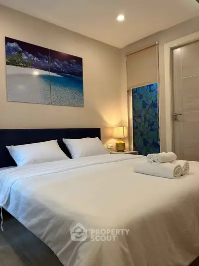 Cozy bedroom with modern decor and ambient lighting, featuring a comfortable double bed and stylish artwork.