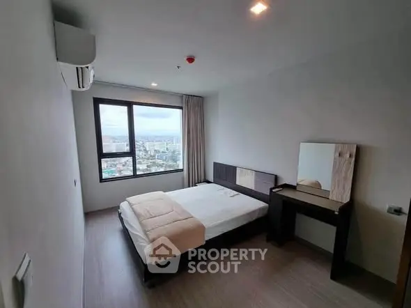 Modern bedroom with city view, featuring a cozy bed and stylish furniture, perfect for urban living.