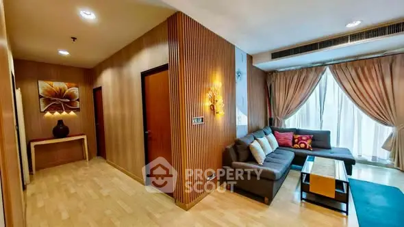 Spacious living room with modern decor and large windows in a stylish apartment.