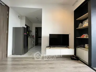 Modern living room with sleek TV setup and compact kitchen area