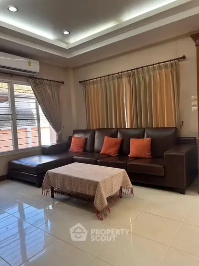 Spacious living room with elegant leather sofa and large windows